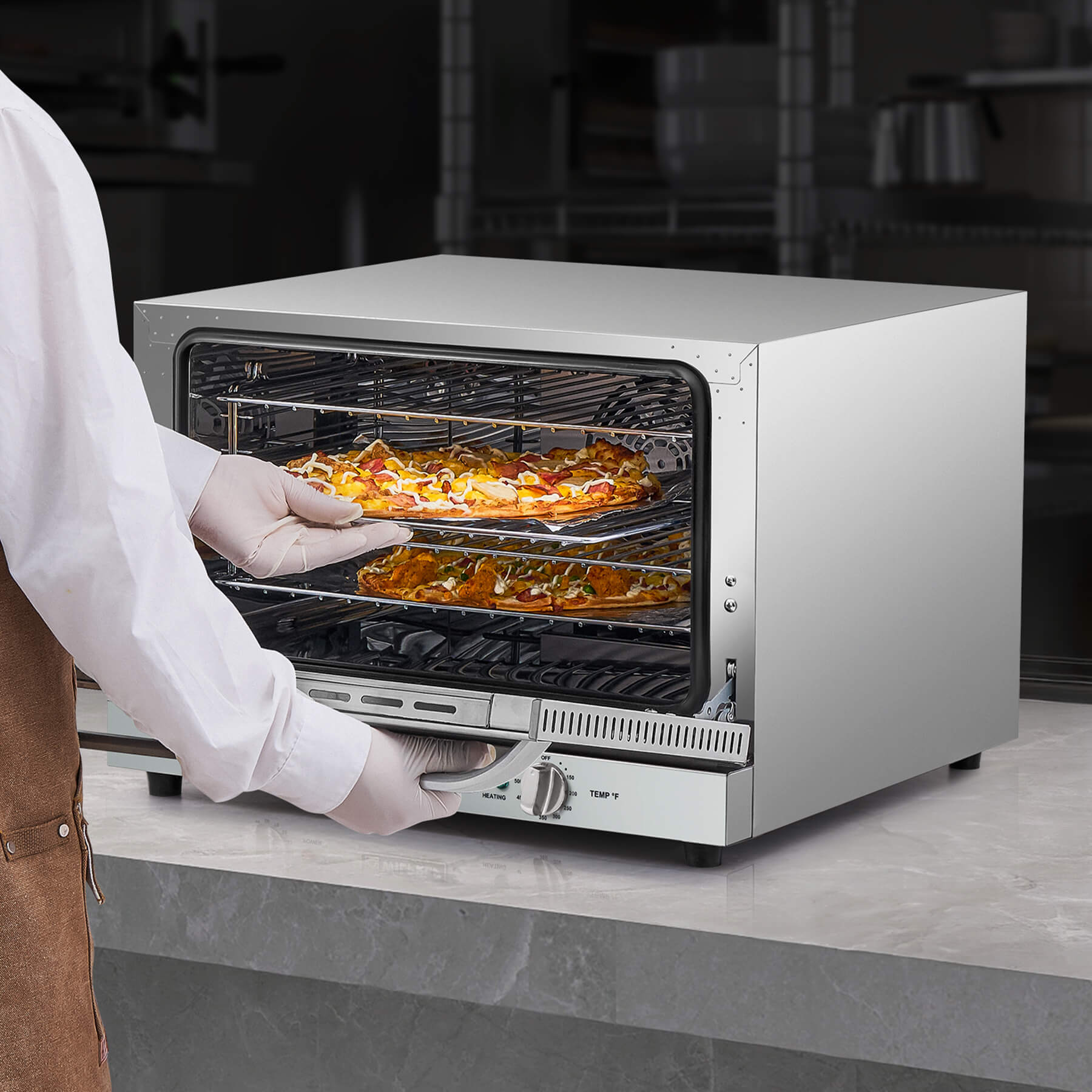 A countertop convection oven with a visible interior rack, temperature control knobs, and a glass door.