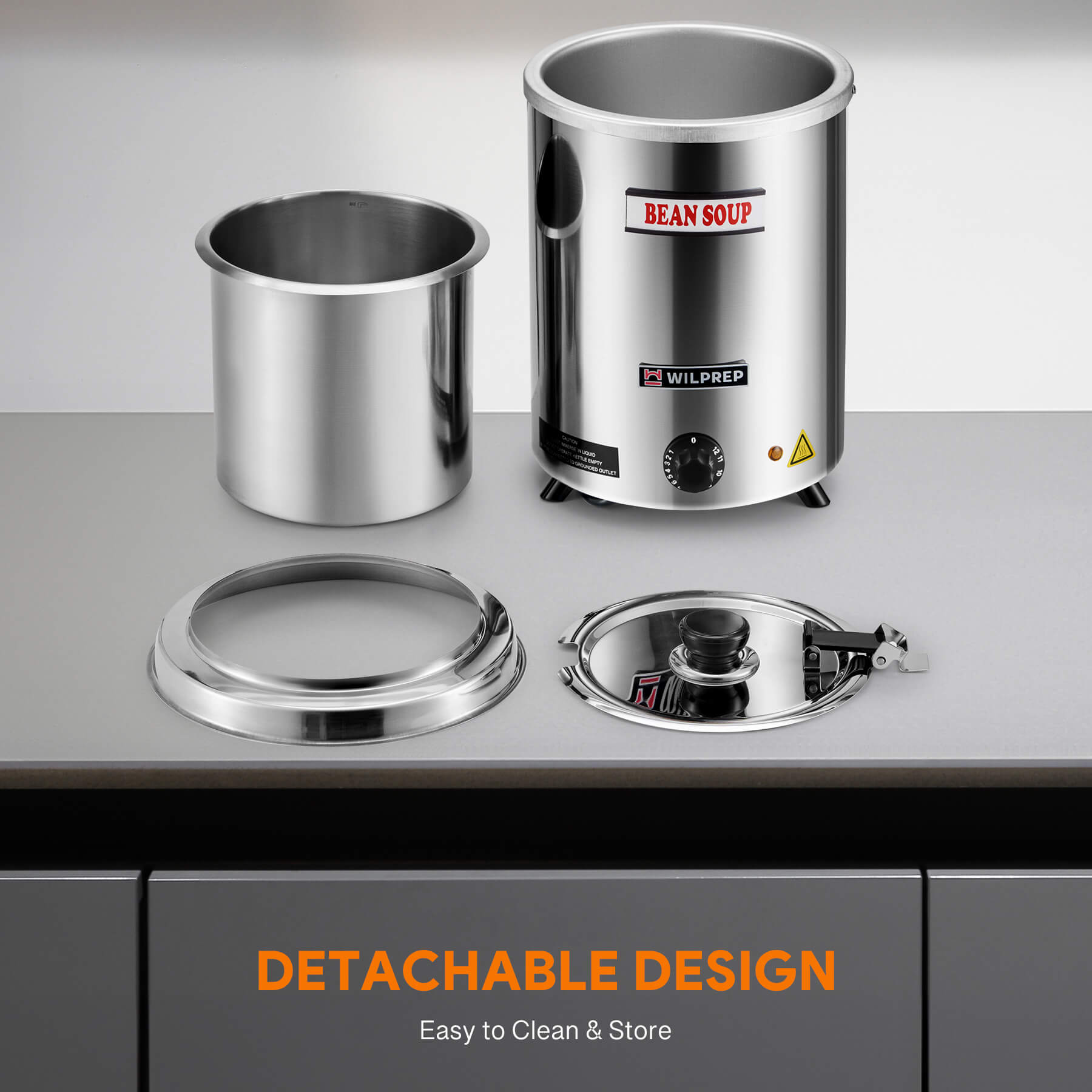 A 6 qt stainless steel soup kettle warmer with a detachable lid, collar, and inner pot. It has a 'BEAN SOUP' label on the front, a temperature control knob, and a handle on the front.