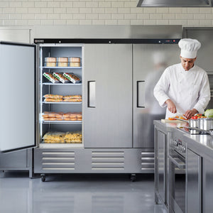Chef preparing food in a professional kitchen with a large refrigerator.