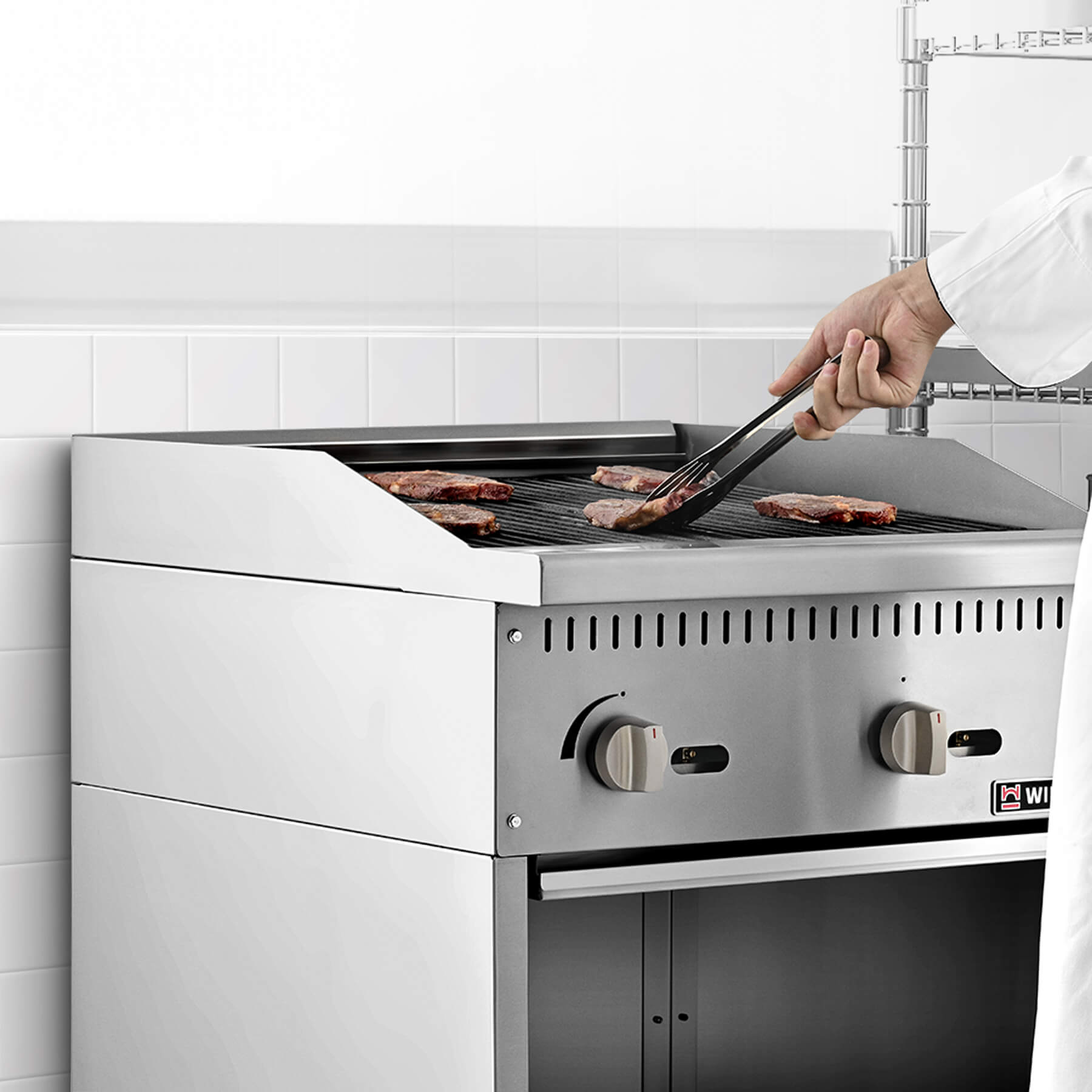 A 24-inch Wilprep comercial natural gas charbroiler with two burners, reversible grates, and a storage base beneath, presented in a stainless steel finish.